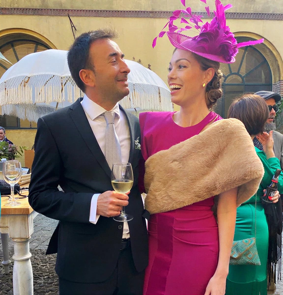 Couple at a Spanish wedding — fascinator and dark suit